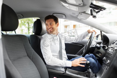 交通、车辆和驾驶概念-微笑的男人或汽车司机回头看。微笑的男人或开车的司机