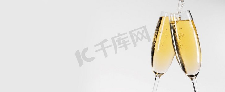 党周年摄影照片_两杯香槟在白色背景，倒葡萄酒。两杯香槟
