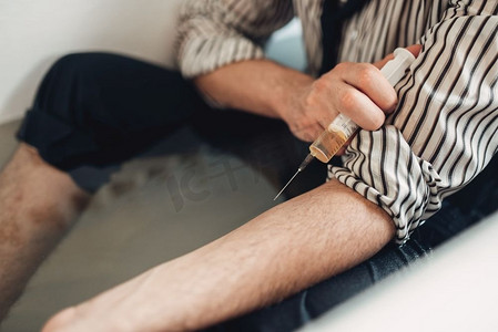 商人破产想死于药物过量,自杀者坐在浴缸里给自己注射器注射.手链手镯