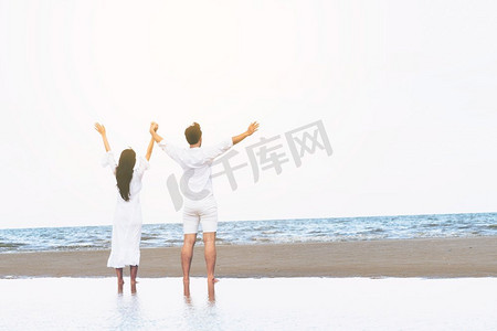 夏日在热带沙滩上度蜜月的幸福夫妻。