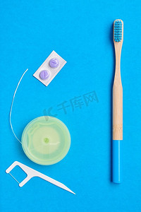 牙刷和口腔护理工具放在蓝色背景上方，俯视复印空间平放。牙齿护理、牙齿卫生和健康理念。