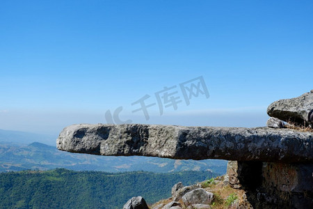 山顶上的岩石和蓝天背景/田野中的风景