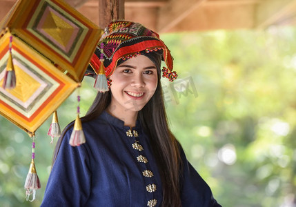 亚洲妇女泰国风格服饰部落Tai Dam/美丽的年轻女孩的画象微笑的泰国传统服装穿着与织物编织在头上 