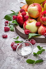 新鲜的乌藨子和苹果在一个具体背景的老木盘子。健康的概念。天然健康食品有机食品。