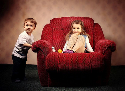 大目标小目标摄影照片_搬到另一个公寓，孩子们搬了一把红色的大椅子。