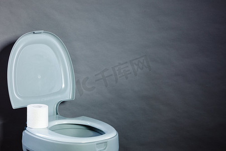 厕所小便摄影照片_用纸卷打开便携式马桶，复制空白处的文字。开放式马桶