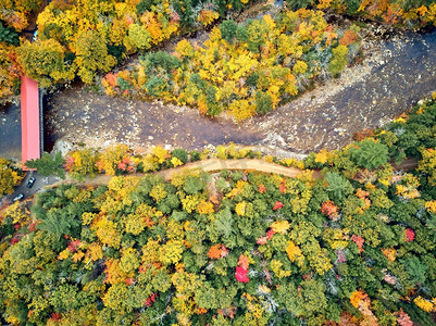 汉普郡摄影照片_风景公路覆盖奥尔巴尼桥在秋天在新罕布什尔州，美国。秋天在新英格兰。空中无人机射击。 