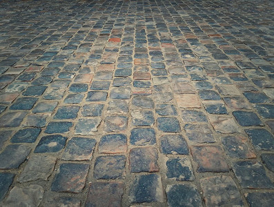 旧的五颜六色的石头复古路面纹理。花岗岩鹅卵石的抽象背景。