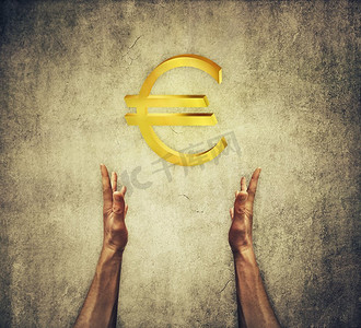 两个人的手拿着一个金色的欧元标志特写。金融理念