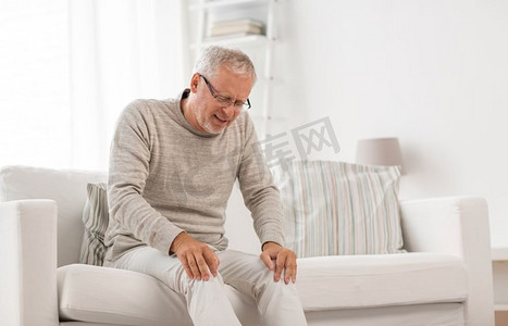 人、医疗保健与问题观念--家中膝盖酸痛的不快乐老人。家中膝盖酸痛的老年男子