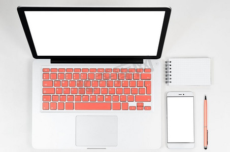 笔记本电脑与生活珊瑚色键盘与智能手机和笔记本，从上面的看法。带智能手机的笔记本电脑