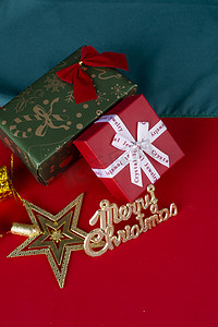 红色立牌摄影照片_字母牌送礼圣诞节平安夜红底图纯色蝴蝶结金色礼物