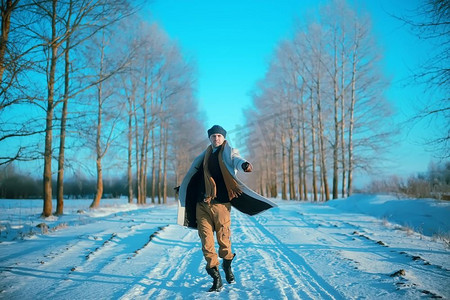背景雪天摄影照片_穿着大衣/冬装的时尚男士，在冬日风景的映衬下行走，雪天，暖和的衣服