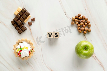 vs框摄影照片_不健康奶油馅饼巧克力vs健康榛子苹果纹理背景