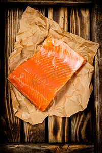 一大块腌鲑鱼放在木托盘上。宏观背景。高质量的照片。一大块腌鲑鱼放在木托盘上。 