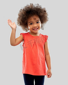 孩子动手摄影照片_童年和人概念—愉快的小非洲裔美国人女孩挥动手在灰色背景快乐的小非洲裔美国人女孩挥舞着手