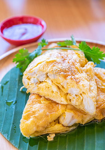 泰国煎蛋卷蟹，蟹肉煎蛋，泰国著名的街头美食和餐厅美食的木桌。