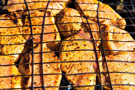 腌猪肉辣牛排在braai烤。烧烤与美味的肉在烤架顶视图。户外季节烹饪假期野餐。