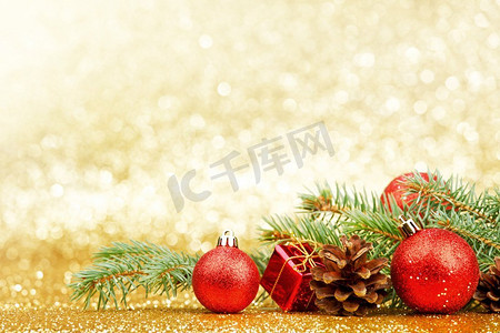 金色闪光摄影照片_圣诞卡与冷杉树枝和装饰在金色闪光背景