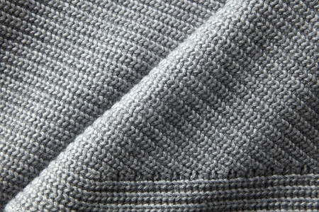 乳汁摄影照片_一整页的灰色针织毛衣材质特写。灰色针织毛衣面料质地