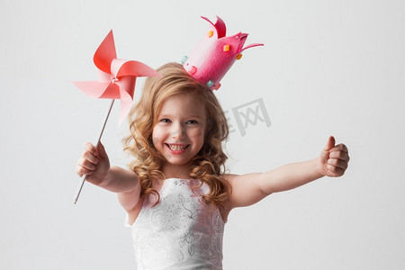 美丽的小糖果公主女孩在冠拿着风车和微笑。糖果公主女孩与风车