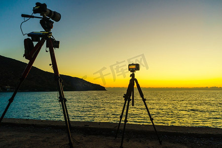 专业摄像机拍摄的照片电影视频日落在海面，希腊伯罗奔尼撒。拍摄海面日落照片的相机