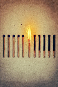 路西法摄影照片_燃烧的火柴站在中间一排完整的，新的火柴在左边，熄灭在右边.领导理念