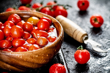 在桌子上腌制成熟的自制西红柿。黑色背景。高质量的照片。在桌子上腌制成熟的自制西红柿。 