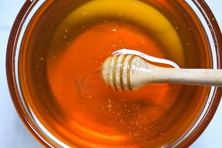 从木制蜂蜜勺滴下的蜂蜜，放在瓶子里，近距离观察