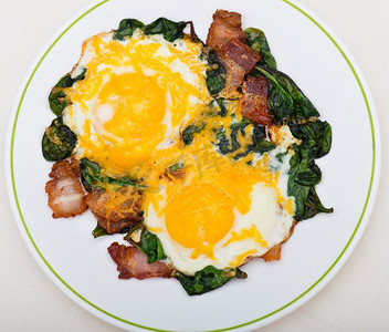 Keto节食早餐，有鸡蛋、菠菜和培根。低碳水化合物高脂肪早餐。