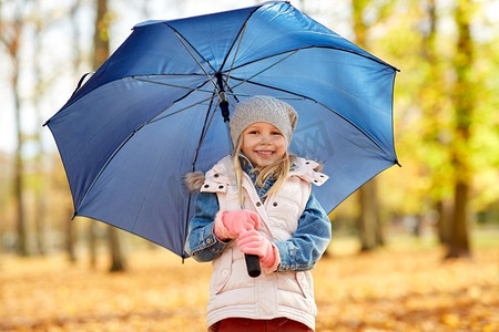童年、季节和天气的概念-秋天公园里打伞的快乐小女孩。秋天公园里撑着伞的快乐小女孩