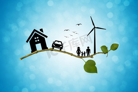 环保绿色能源理念。幸福的家庭，房子，汽车和风车剪影在树枝上