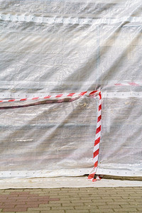 建筑工地的危险警告胶带。红色和白色的条纹轻织物。建筑工地的危险警告带