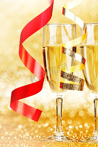 香槟和红丝带的杯子在金色背景