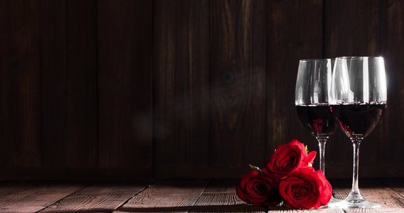 情人节，两杯红酒和三朵玫瑰。葡萄酒和玫瑰