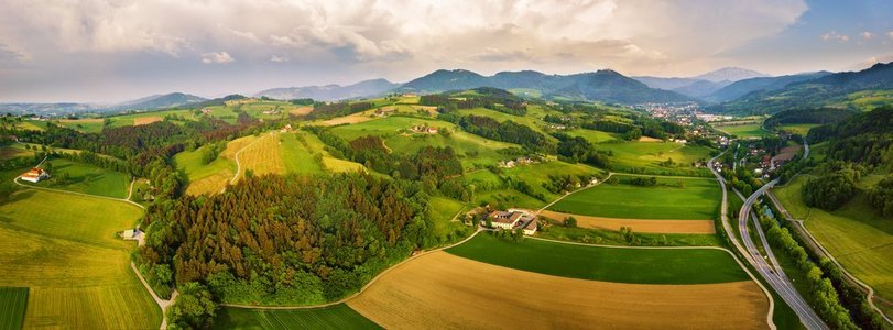 春天在奥地利旅行绿色的田野和草地在阿尔卑斯山。在阿尔卑斯山的乡村的交叉路口。 