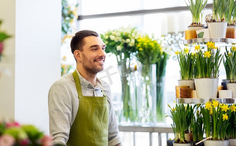 销售，小企业和花店概念—快乐的微笑花店人或卖家在花店。花店柜台的卖花人或卖花人