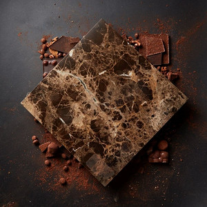 文本的大理石牌匾和黑色背景上的巧克力粉。不同的巧克力和可可粉