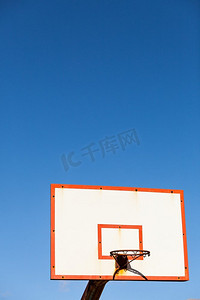 篮球蓝色摄影照片_篮球板与篮筐反对蓝天。运动，娱乐...篮球篮反对蓝天