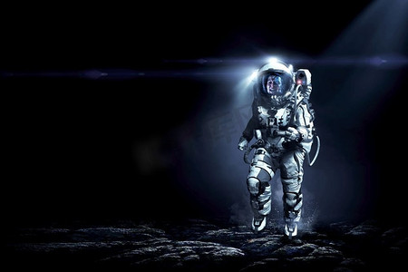 穿着宇航服的宇航员在行星表面运行。混合媒体。太空人跑得很快。混合媒体