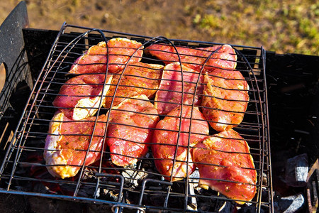 腌猪肉辣牛排配芒果烤。烧烤与美味的肉在烤架顶视图。户外季节烹饪假期野餐。