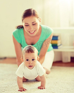 家庭、孩子和为人父母的概念—快乐微笑的年轻妈妈在家里玩小宝宝。快乐的母亲玩与宝宝在家里