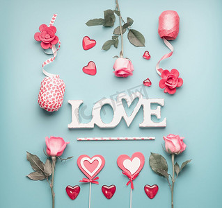 词爱与玫瑰，心和装饰丝带在粉彩蓝色背景，顶视图.情人节或抽象爱情概念