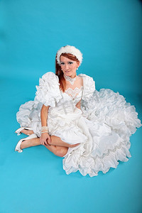 梦幻雪摄影照片_美丽的姜在雪女王蓝色背景的白色连衣裙