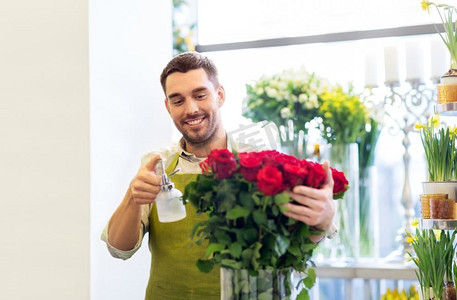 小企业，销售和花艺概念—花商或卖方设置红玫瑰在花店。在花店里摆放红玫瑰的花店或售货员