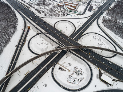 积雪覆盖摄影照片_冬季积雪覆盖的高速公路十字路口的鸟瞰。