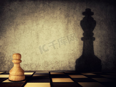 棋子投射在混凝土墙上的国王的影子。企业抱负和领导理念。魔法转化