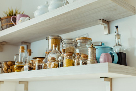 开放式厨房背景摄影照片_斯堪的纳维亚式厨房，开放式货架上各种食品和香料原料装在玻璃瓶里。开放式货架上摆放着各种食物和香料原料