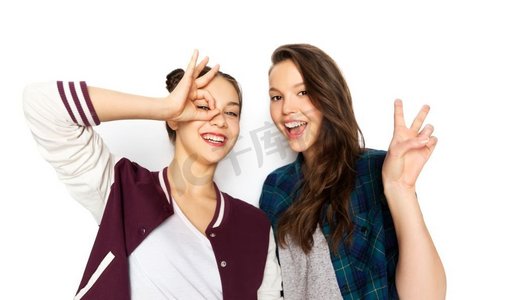 十几岁的少女摄影照片_人和友谊概念—愉快的微笑漂亮的十几岁的女孩做手势在白色背景。快乐的微笑少女做手势