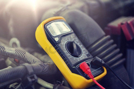 汽车维修、维修和保养理念—数字万用表或电压表测试汽车蓄电池。电动汽车电池电压表测试